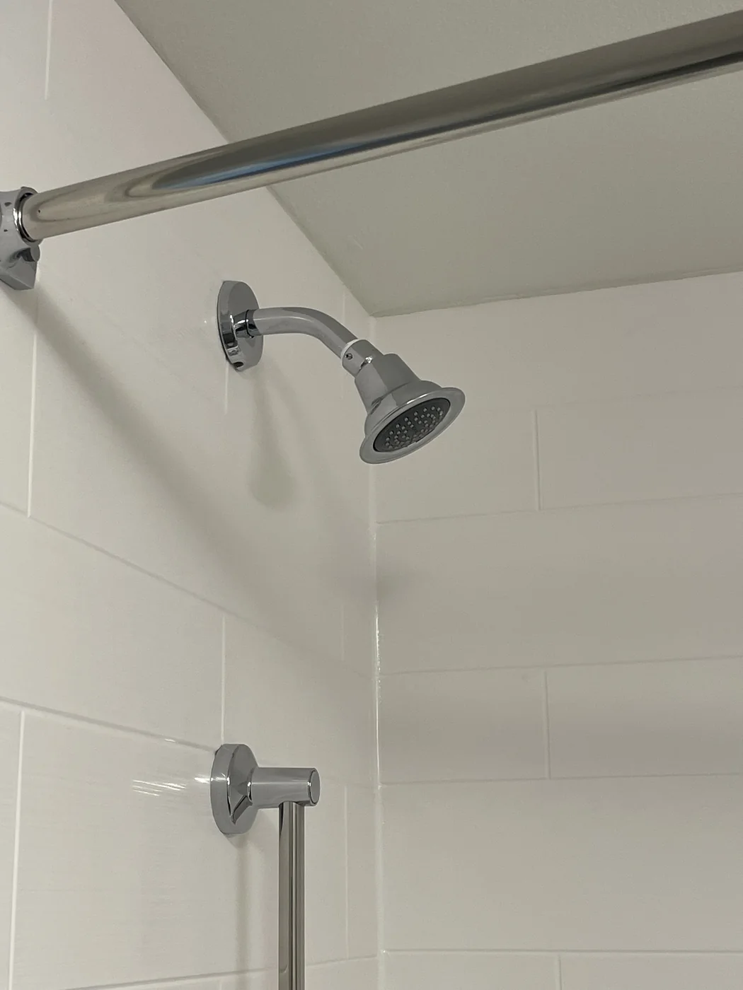Close view of a shower fixture and tiled wall